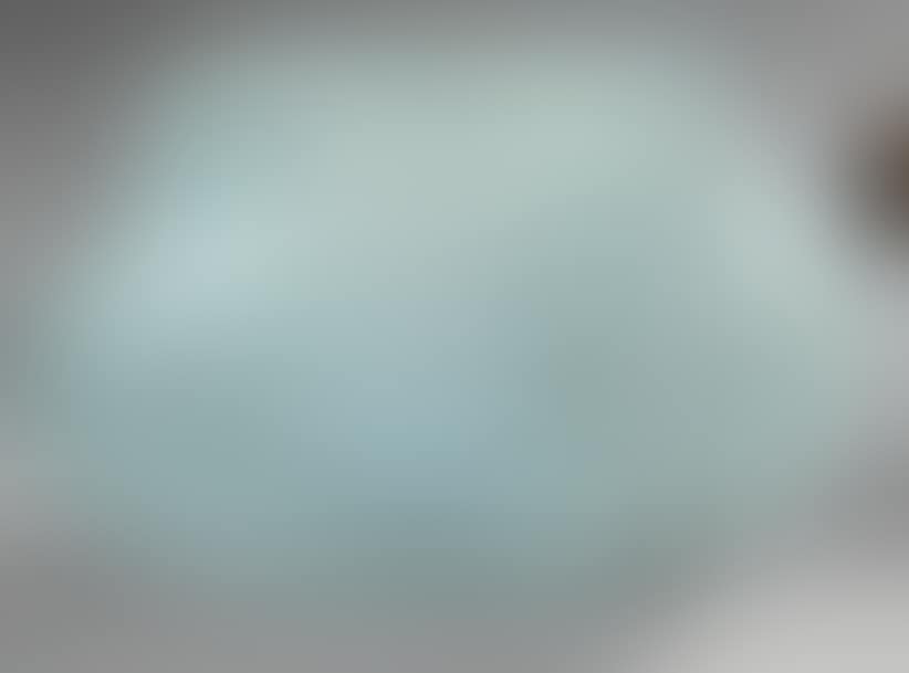 Oblong vase in white marmoreal glass on a bluish marmoreal background (preview)