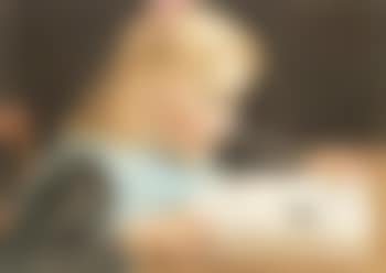 Blonde haired girl reading book at table (preview)