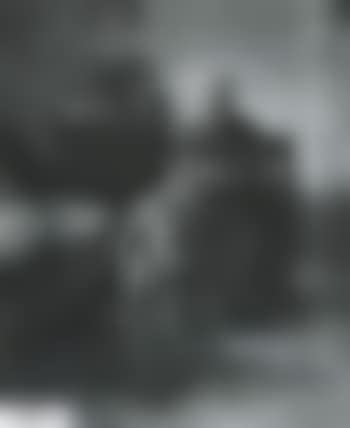 Mother and child seated at a table, mother sewing (preview)