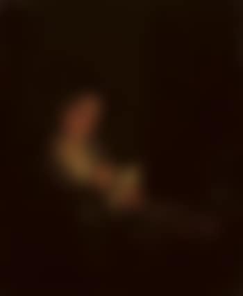 Candlelit interior with a young man seated at a table, lighting his pipe (preview)