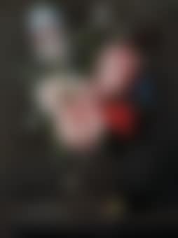 A tulip, roses, iris and other flowers in a glass vase on a ledge (preview)