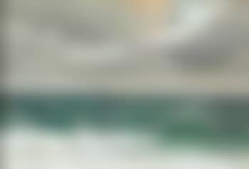 View of the sea with a sailing ship on the horizon, the sun breaks through the clouds (preview)