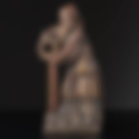 Character Standing, he presents a twisted crown in his hands; wearing a cap with a long fall coming back to the front, he is dressed in a long dress and a slit tunic tightened by a belt to which a chaplain and a dagger are attached (preview)
