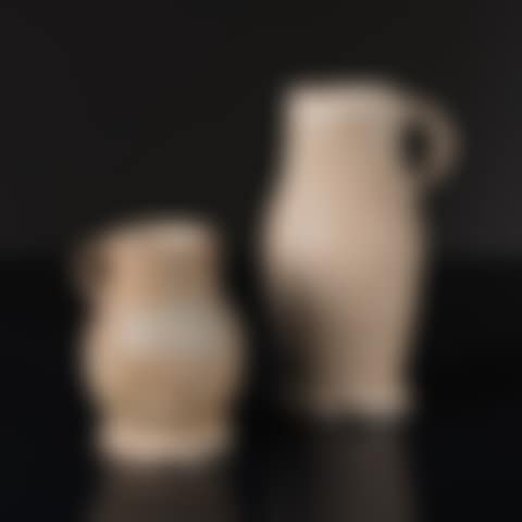 pitchers each with a handle, swollen and ribbed body resting on a flared base (preview)