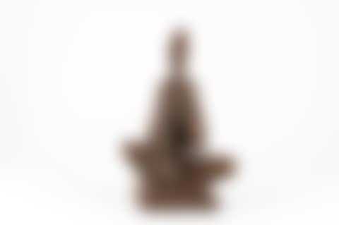 A ceramic sculpture of a seated muscian playing a wind instrument (preview)