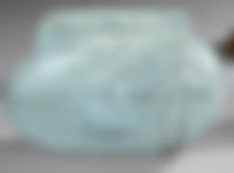 Oblong vase in white marmoreal glass on a bluish marmoreal background (preview)