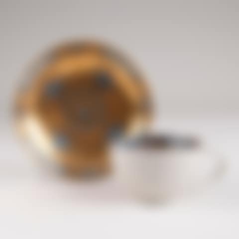 Cup with blue straw flowers in front of a gold background (preview)